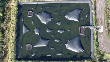 Covered biomass storage bunker in rural landscape. © Maik