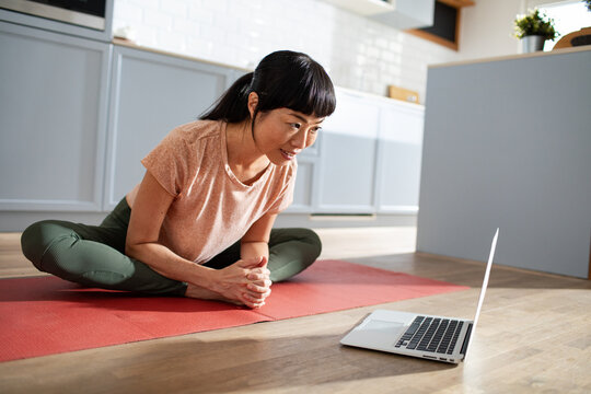 Woman following online yoga class at home