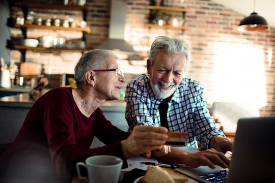 Senior couple shopping online with laptop at home