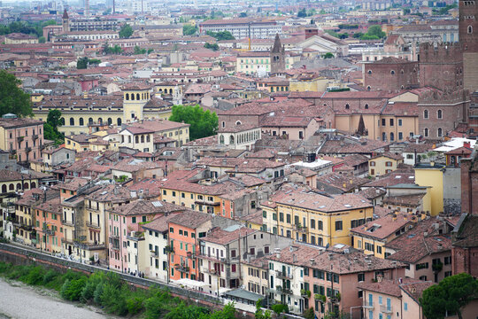Aerial view of the historic old town featuring dense terracotta rooftops and colorful buildings along the riverbank Verona, Veneto, Italy.