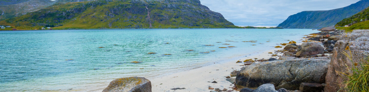 Fjord in rainy weather. Rocky beach in evening, White sand on the beach. Beautiful nature of Norway. Lofoten islands