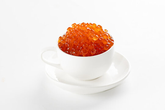 Red caviar in a white porcelain cup. An exquisite snack. Useful omega. White cup with porcelain saucer. Place to copy. An isolated object.