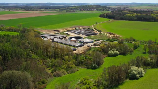 Biogas plant and farm in fields. Renewable energy from biomass. Aerial view to Czech industry. Sustainable development in European Union.