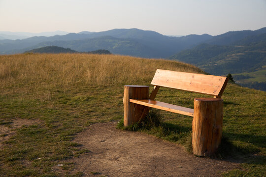 a wooden bench in the mountains invites to linger