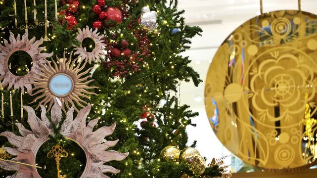 A decorated Christmas tree against the backdrop of a swinging clock pendulum.