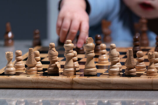 Future grandmaster concept, toddler exploring chess pieces with curiosity and focus