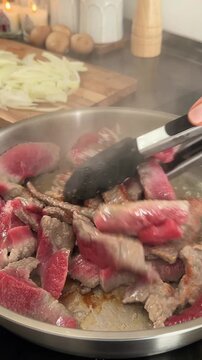 Cooking homemade Beef Stroganoff with creamy mushroom sauce and mashed potatoes in a cozy kitchen