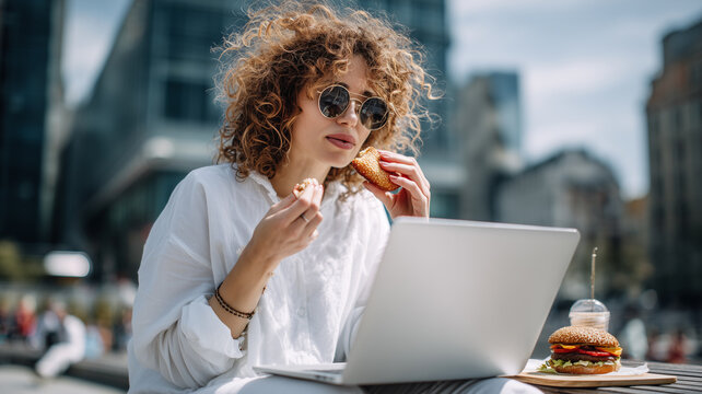 Freelancer enjoying lunch outdoors while focused on work at a cafe