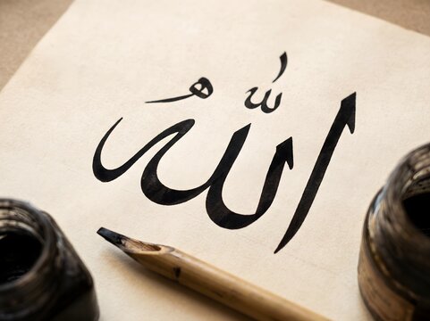Artistic Scene of Arabic Calligraphy Process featuring Name of Allah with Traditional Qalam Pen and Inkwell