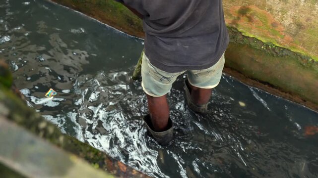workers clean a clogged roadside drainage canal