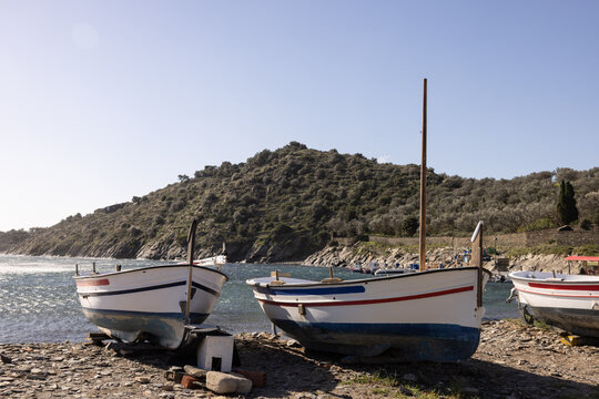 boats on shore in Cadaques, Spain, next to white building