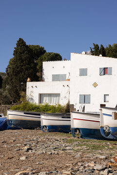 boats on shore in Cadaques, Spain, next to white building