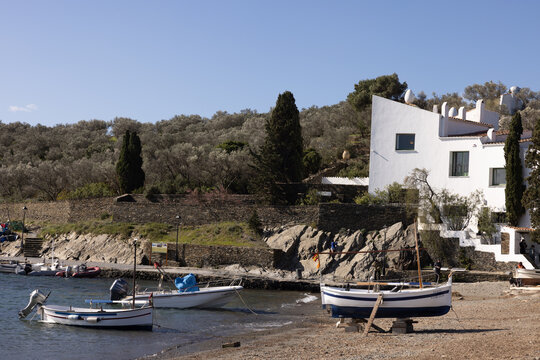 boats on shore in Cadaques, Spain, next to white building