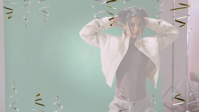 Female model releasing pose and adjusting puffer jacket with metallic streamers for fashion shoot