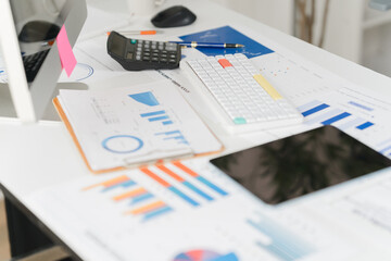 Fototapeta premium Businesswoman using calculator and laptop computer for analysis maketing plan, Accountant calculate financial report, computer with graph chart. Business, Finance and Accounting concept
