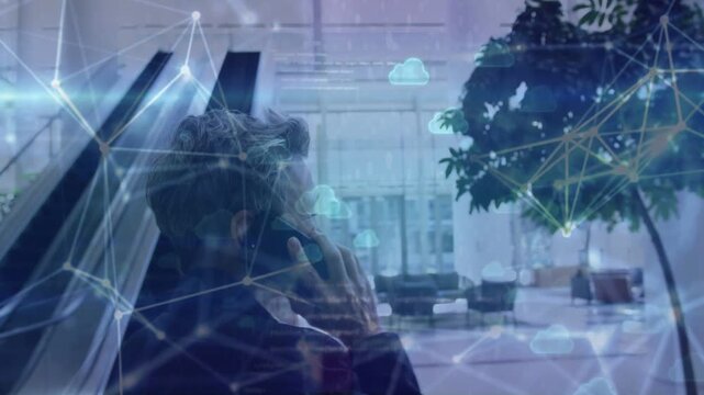 Man walking through lobby, speaking on smartphone and activating animated tech nodes, clouds rising