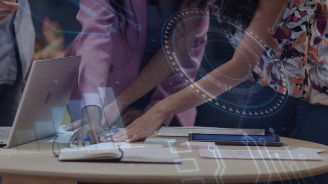 Third person reaching laptop, team arranging papers for review, business HUD overlays marking data