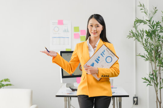 Smart Presentation in Office: An elegant professional confidently presents ideas in a modern office. Her poise and polished demeanor inspire trust and showcase professional excellence. 