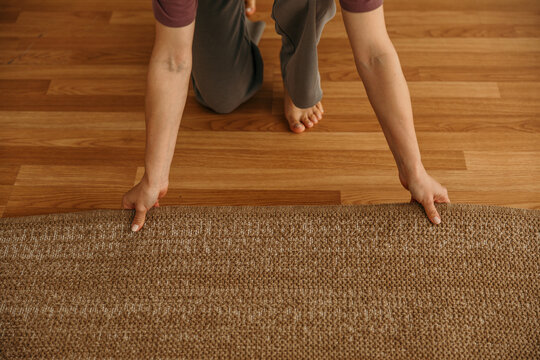 Woman unrolling yoga mat for home exercise routine
