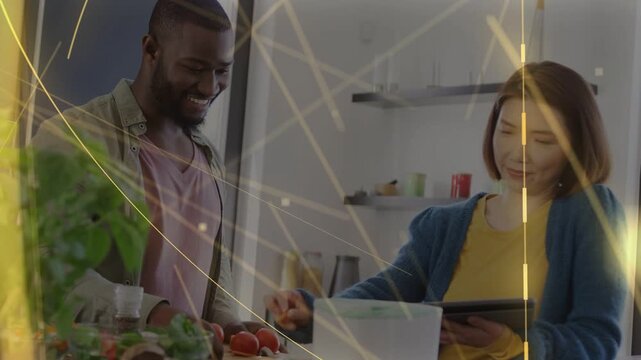 Man chopping tomatoes adding to bowl as woman tapping tablet guiding cooking gold overlay streaking