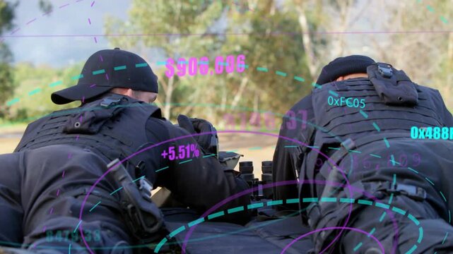Two tactical ops prone on range mat, left operator raising rifle updating AR HUD for targeting