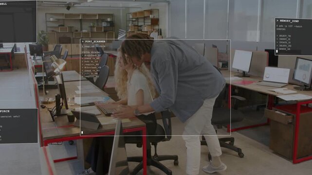 Man walking assisting woman typing in office, leaning, pointing at monitor HUD highlighting entries