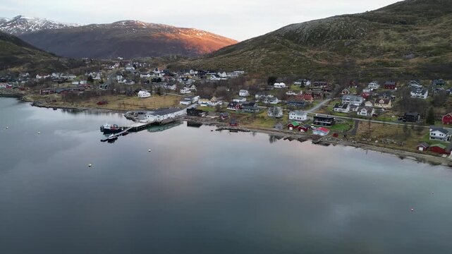 Aerial Drone Panning Over Still Lake with Town Reflection and Sunset Glow Behind Mountain, Troms&oslash;, Norway