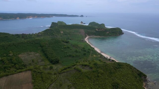 Aerial Coastal Village And Coral Flats,Long Sandy Ribbon Curving Along Shallow Turquoise Shelf, Scattered Houses And Vegetation,Reef Patterns Visible Through Clear Water, Katil beach,Lombok,Indonesia