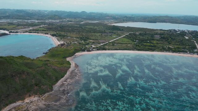 Aerial Green Island Cape With Curved Beaches, Rolling Hills And Farmland Pockets, Long Reef Line Shaping Waves, Secluded Bays, Turquoise Shallow Water Meeting Deep Ocean, Katil beach,Lombok,Indonesia