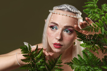 Naklejka premium Beautiful elf girl with floral decor on dark olive background