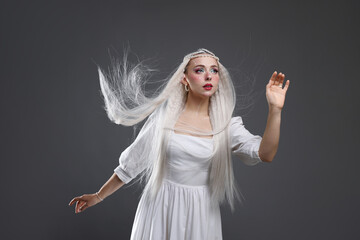 Naklejka premium Beautiful girl dressed as elf on grey background