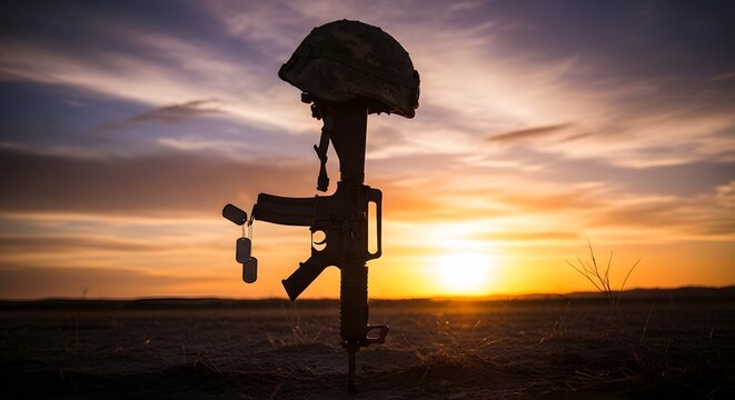 Battlefield cross memorial silhouette at sunset honoring fallen soldiers