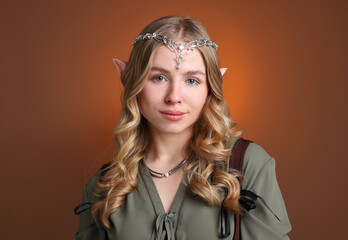 Naklejka premium Beautiful girl dressed as elf on brown gradient background