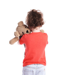 Obraz premium Little boy hugging plush toy bear on white background, back view