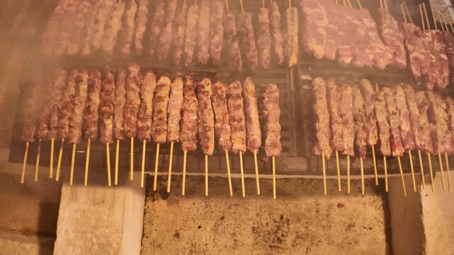 View of the greek meat dish Souvlaki cooked on long skewer over a charcoal barbecue