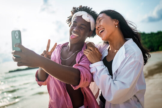Diverse content creator couple vlogging or streaming from a scenic tropical beach on summer vacation