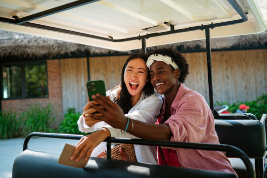 Diverse content creator couple vlogging or streaming from a scenic tropical beach on summer vacation