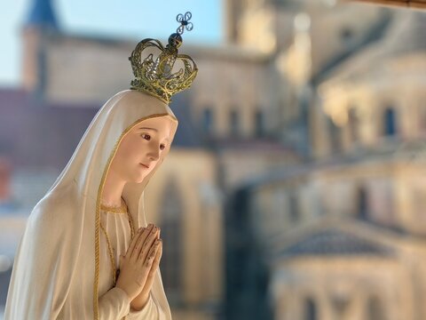 Statue of the Virgin Mary praying with her hands joined ,with a crown. Our Lady of Fatima in front of the basilica of Paray-le-Monial, France.