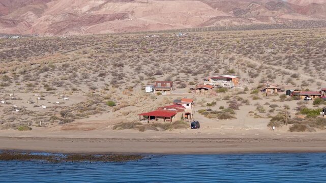Aerial views show the sunrise lighting up Bahia De Los Angeles in Baja California Mexico. View the beach and nearby camping areas.