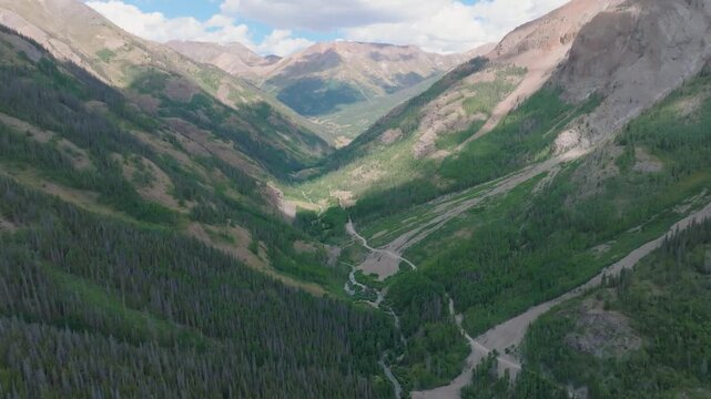 Aerial view of Cinnamon Pass switchbacks and high-altitude peaks in Colorado mountains.