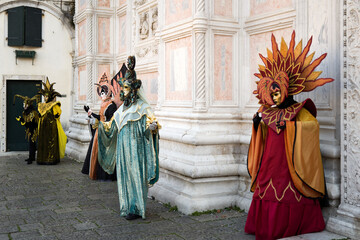 Fototapeta premium Venice, Italy - February 17, 2026 - People dressed in masks for the Venice Carnival have their photos taken by tourists