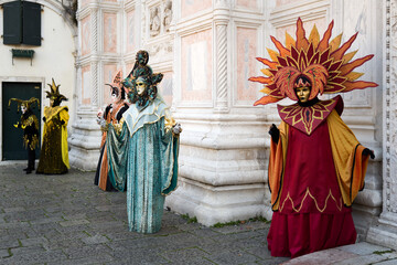 Naklejka premium Venice, Italy - February 17, 2026 - People dressed in masks for the Venice Carnival have their photos taken by tourists