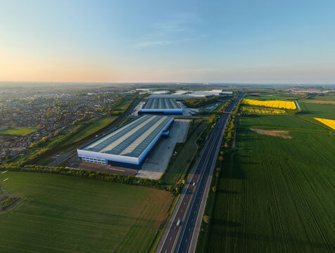 Aerial view of large industrial warehouses and distribution centers next to a motorway and green fields Armthorpe, England, United Kingdom.