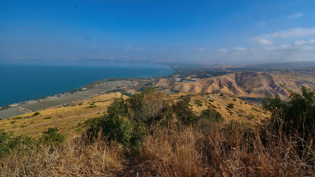 Panoramic view of Sea of Galilee (Kinneret) with Bethsaida Valley farmland, Jordan River delta, and Golan Heights summer landscape from Mitzpe Ofir viewpoint, Northern Israel, Holy Land
