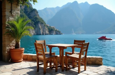 Fototapeta premium Wooden table and chairs set on stone patio beside calm turquoise sea. Mountains backdrop with boat sailing on water. Tropical palm tree adds exotic vibe.