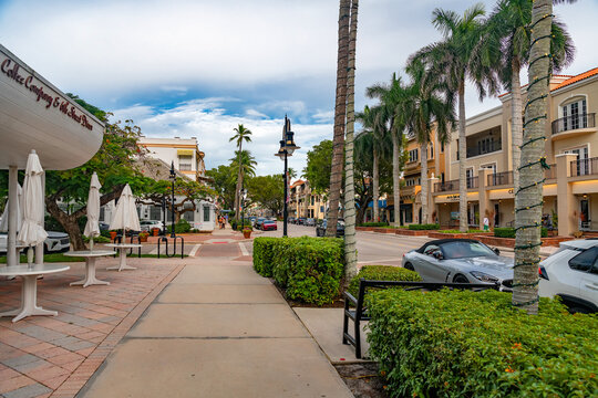 City street with shops cars and palm trees in Naples Florida residential commercial area