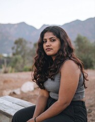 Fototapeta premium Young South Asian woman outdoor portrait with mountains in background