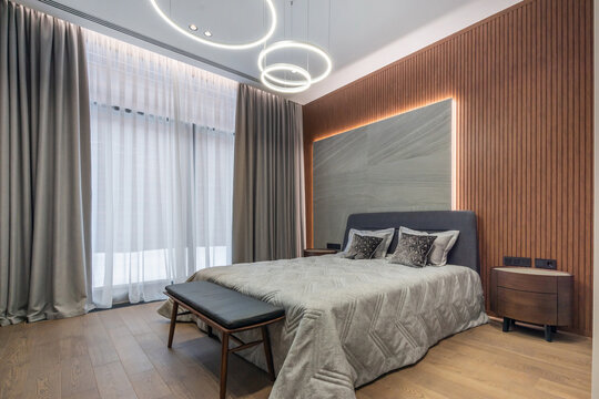 The interior of the bedroom has a modern design. Panoramic window with a winter landscape.