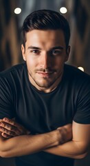 Obraz premium Portrait of a young man with arms crossed, looking at the camera with a confident expression