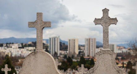 Cemetery crosses with blurred social housing in Marseille, France © C